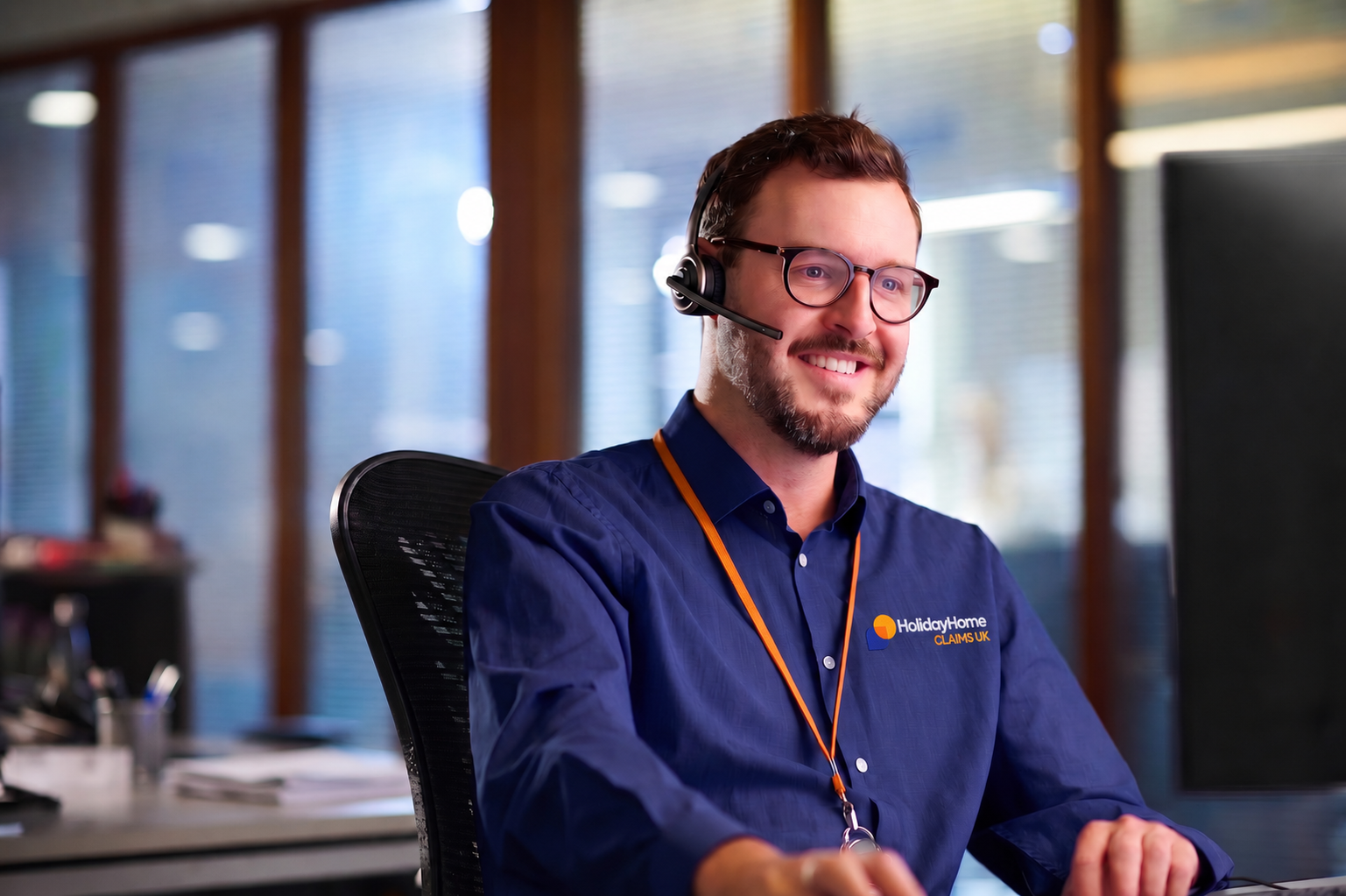A member of the claims team wearing a headset at a desk in the office