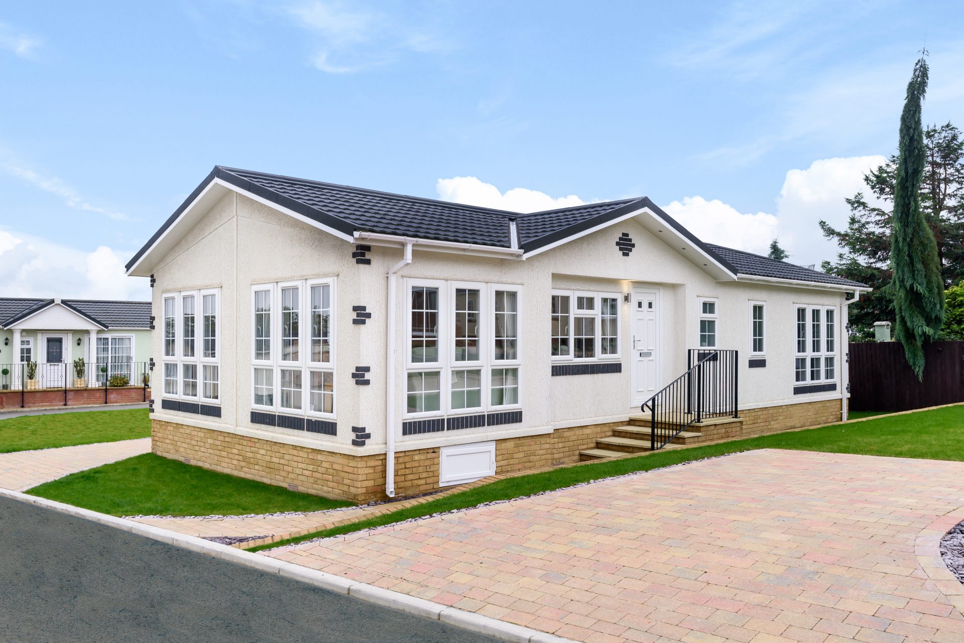 A residential park home with a garden and driveway