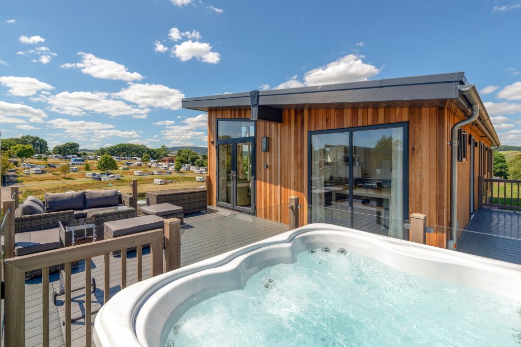 A timber holiday lodge with decking in the countryside